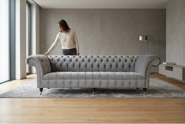 Clásico sofá Chesterfield de 4 plazas en cuero gris de diseño acolchado.