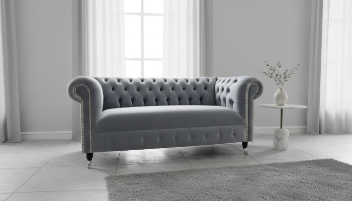 Sofá moderno de tres plazas Chesterfield gris acolchado.
