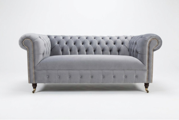 Sofá moderno de tres plazas Chesterfield gris acolchado.