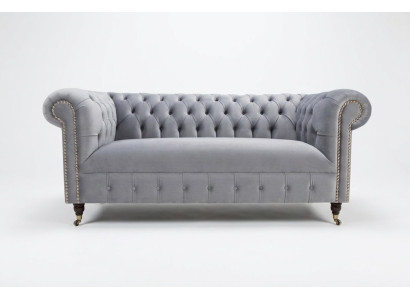Sofá moderno de tres plazas Chesterfield gris acolchado.