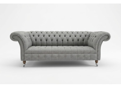 Sofá Chesterfield de diseño de tela gris de tres plazas para la sala de estar.