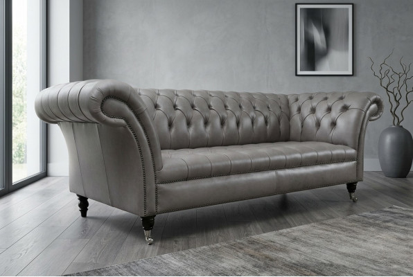 Sofá Chesterfield gris de tres plazas exclusivo para la sala de estar.