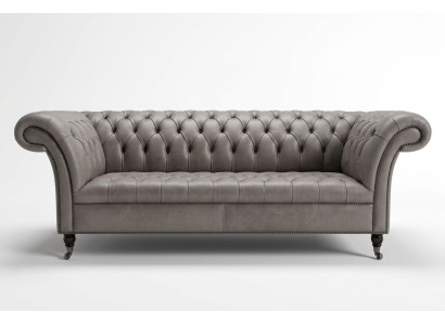 Sofá Chesterfield gris de tres plazas exclusivo para la sala de estar.