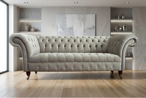 Estiloso sofá Chesterfield de tres plazas de color gris claro para salón de lujo.