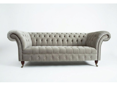Estiloso sofá Chesterfield de tres plazas de color gris claro para salón de lujo.