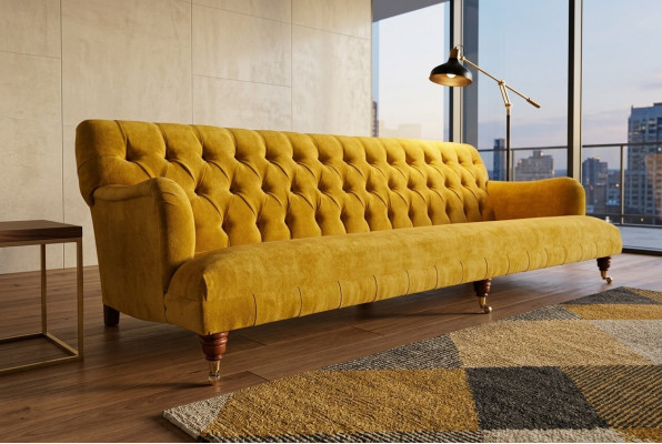 Sofá Chesterfield clásico de 4 plazas en cuero amarillo diseño tapizado.