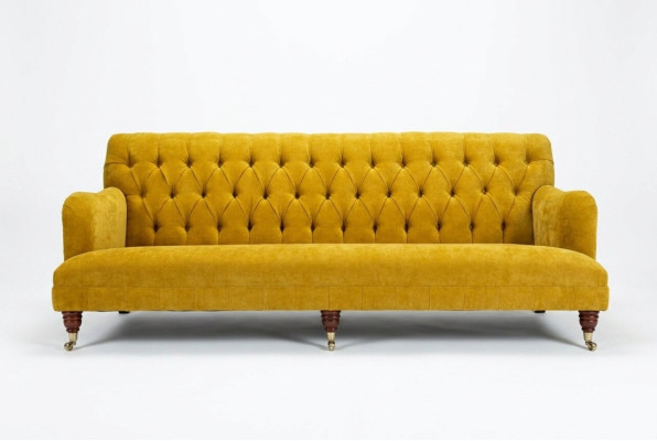 Sofá Chesterfield clásico de 4 plazas en cuero amarillo diseño tapizado.