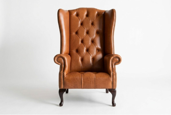 Sillón Chesterfield, sillón de orejas, sofá de tela, tela de tela, cojines marrones, sala de estar.