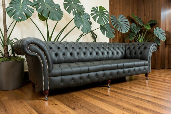 Sofá grande de 4 plazas Chesterfield gris de tela y cuero con cojines.