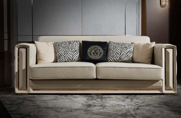 Sofá Chesterfield de cuero beige, sofisticado diseño de sala de estar con cojines.