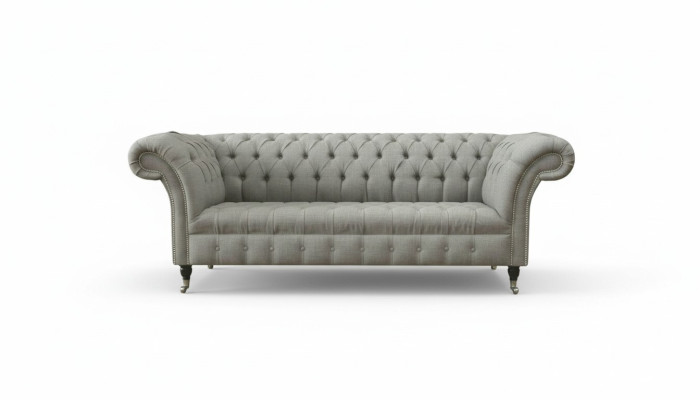 Sofá Chesterfield gris tapizado en tela de cuero y terciopelo.
