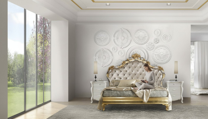 Hermosa cama de estilo clásico con cabecero tallado.