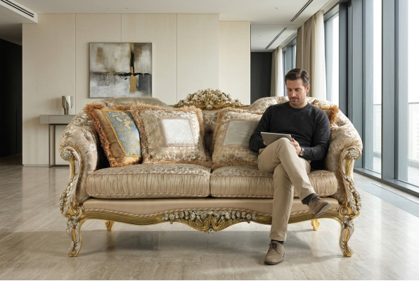 Clásico sofá Chesterfield de dos plazas en color beige con marco de madera.