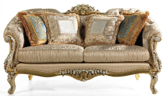Clásico sofá Chesterfield de dos plazas en color beige con marco de madera.