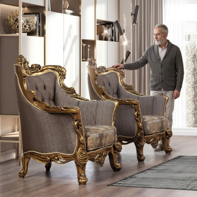 Una lujosa butaca clásica en gris oscuro con diseño barroco dorado de Chesterfield.