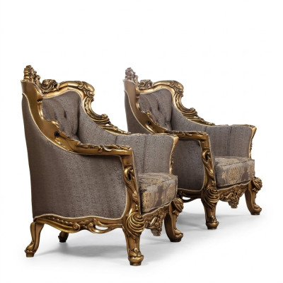 Una lujosa butaca clásica en gris oscuro con diseño barroco dorado de Chesterfield.