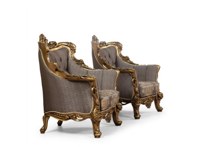 Una lujosa butaca clásica en gris oscuro con diseño barroco dorado de Chesterfield.