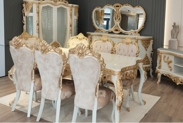 Conjunto clásico de sillas con adornos tallados ricamente decorados en dorado.