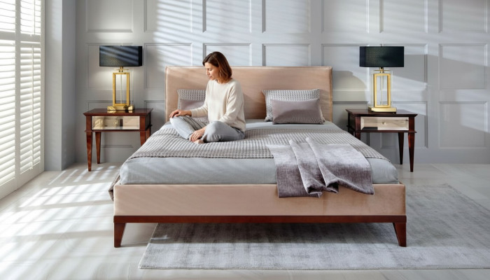 Moderno dormitorio beige y marrón con cama de lujo de madera nueva.