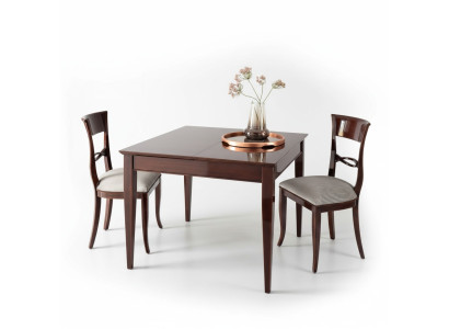Elegante mesa de comedor con sillas en color marrón oscuro con superficie brillante.