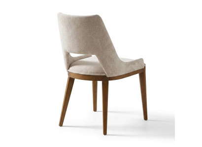 Una silla lacónica y moderna con patas altas de madera y tapizado en un agradable color crema claro para el comedor.