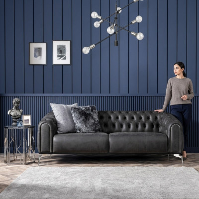 Sofá negro recto de cuatro plazas al estilo Chesterfield para la sala de estar.