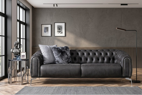Sofá negro recto de cuatro plazas al estilo Chesterfield para la sala de estar.