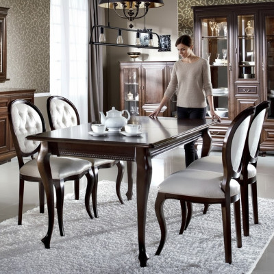 Mesa de comedor de madera marrón oscuro con 5 sillas clásicas de cuero Chesterfield de diseñador.