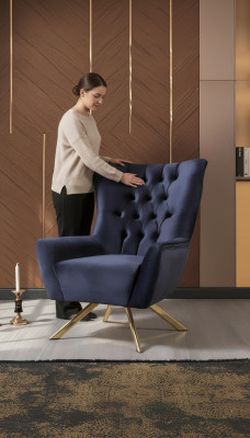 Silla Chesterfield azul de lujo con tapizado de terciopelo para la sala de estar.