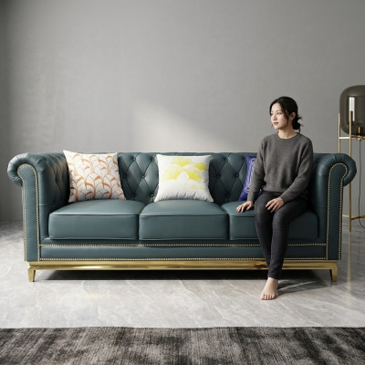 Sofá Chesterfield de tres plazas con estructura de acero inoxidable y tapizado textil.