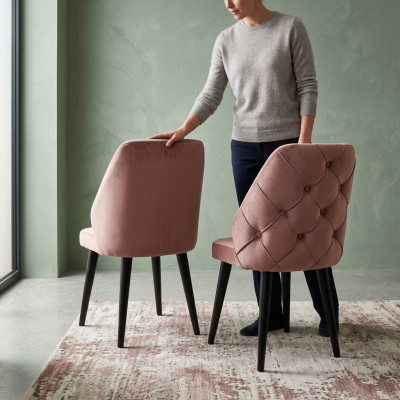 Silla acolchada de madera beige con respaldo Chesterfield y patas negras para comedor.