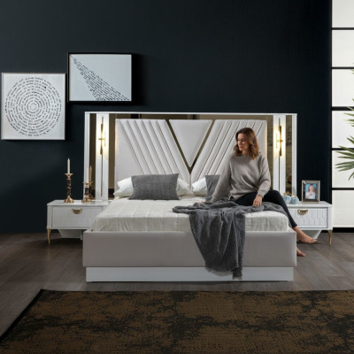Cama de 2 habitaciones con decoraciones doradas y mesitas de noche a juego.