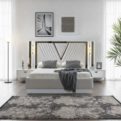 Cama de 2 habitaciones con decoraciones doradas y mesitas de noche a juego.