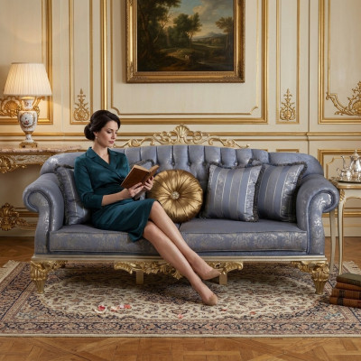Sofá clásico y exigente en diseño Chesterfield para la sala de estar con cojines dorados.