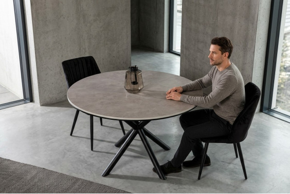 Mesa de comedor redonda extensible de madera gris.