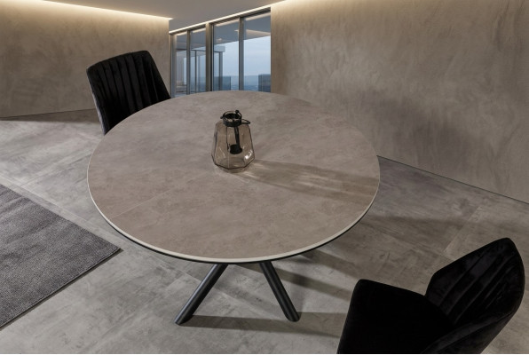 Mesa de comedor redonda extensible de madera gris.