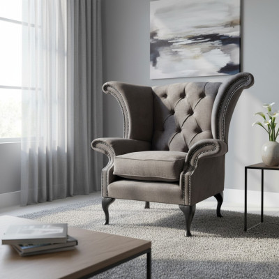 Silla orejera modelo Chesterfield de tela de poliéster gris para sala de estar.
