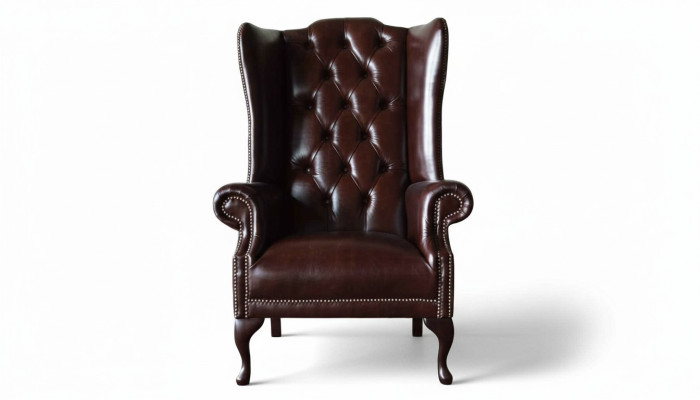 Sillón individual marrón de cuero de diseño Chesterfield para sala de estar.