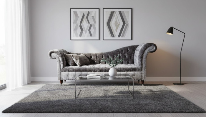 Un lujoso sofá clásico de estilo Chesterfield en un tono plateado profundo.