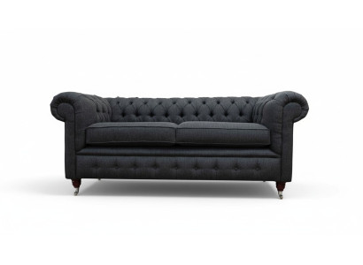 Sofá Chesterfield tapizado de dos plazas en tela gris.
