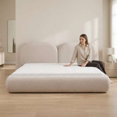 Dormitorio beige con cama doble con cabecero redondo de tela, camas tapizadas nuevas.