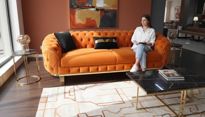Elegante sofá de 3 plazas Chesterfield moderno en color naranja para la sala de estar.