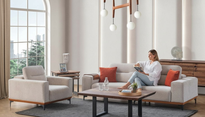 Conjunto de sofá blanco de tres plazas con cojines, sillón, mesa de centro y mesas auxiliares.
