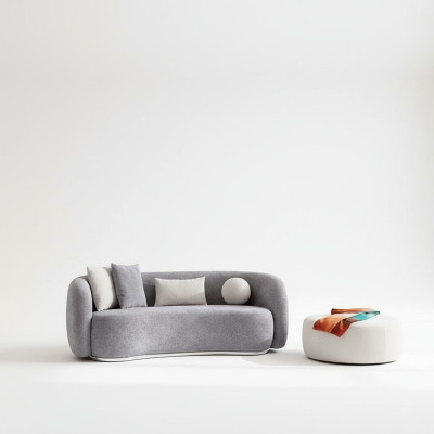 Moderno sofá gris de diseño moderno de cuatro plazas con sofá tapizado y reposapiés nuevos.