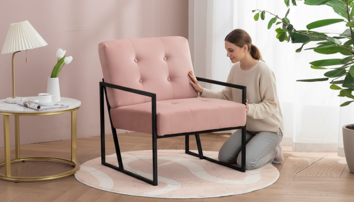 Cómodo sillón de 1 plaza para sala de estar en rosa con tapizado textil y patas de metal.