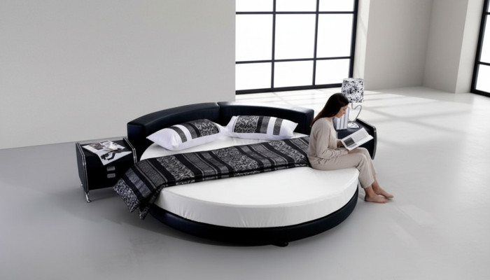 Moderna cama negra con detalles elegantes y un sofá