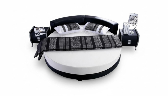 Moderna cama negra con detalles elegantes y un sofá