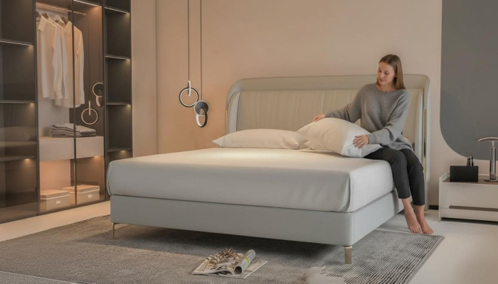 Moderna cama de lujo en gris con un elegante cabecero dorado